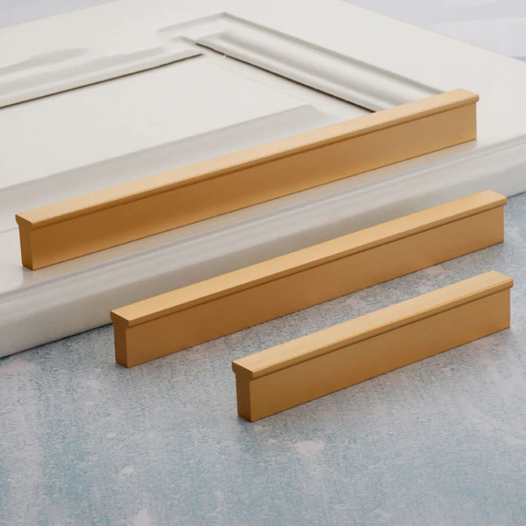 Gebürstete goldene Jimba-Möbelgriffe mit geradlinigem, linearem Design auf hellem Hintergrund