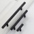 Möbelgriff Uno – T-Bar-Griff mit rundem Profil in Schwarz und gebürstetem Gold. Erhältlich als T-Bar-Knopf sowie in 96, 128, 160, 256, 512 und 850 mm – egriffe.de