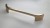Länglicher goldfarbener Möbelgriff Palomo mit einem Lochabstand von 128 mm.