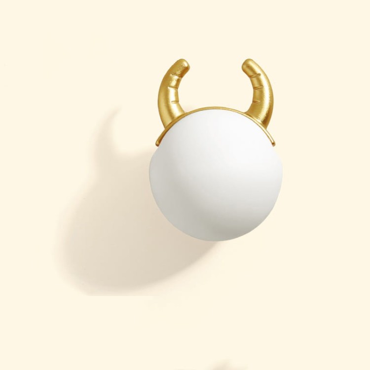 Kindermöbelgriff Cow in Form einer pastellfarbenen Kugel mit goldenen Hörnern verleiht Kindermöbeln Charme – ideal für Schubladen, Kommoden und Schränke im Kinderzimmer.