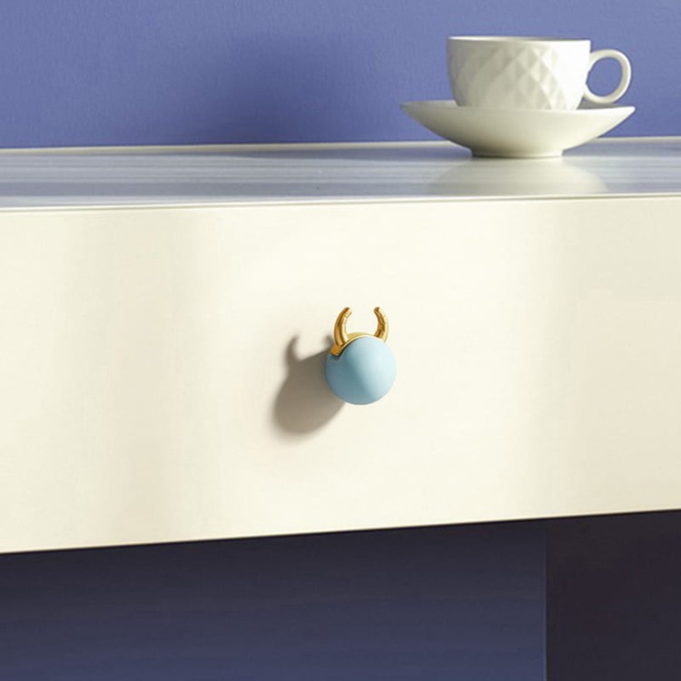 Kindermöbelgriff Cow in Form einer pastellfarbenen Kugel mit goldenen Hörnern verleiht Kindermöbeln Charme – ideal für Schubladen, Kommoden und Schränke im Kinderzimmer.
