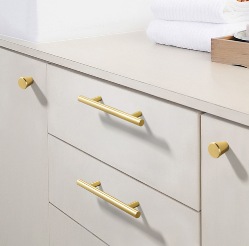 Möbelgriff Alma – schlichter zylindrischer T-Bar-Griff in Gold, Champagnergold oder Schwarz, passend für moderne und klassische Interieurs. Viele Größen für Kommoden, Schränke, Garderoben und Badmöbel.